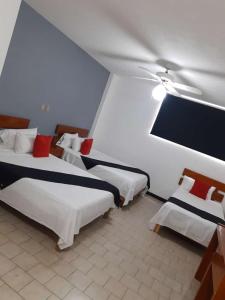 um quarto com 2 camas e uma ventoinha de tecto em HOTEL SiCILIA iTALIA em Aguascalientes