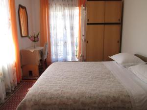 a bedroom with a large bed and a window at Apartments Helena in Primošten