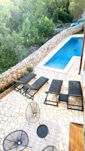 コーニッチにあるVilla Muraj-Kornić, Krkのラウンジチェアとプール