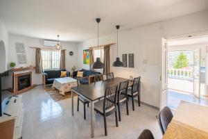 a dining room and living room with a table and chairs at Casa Girasol in Torrox