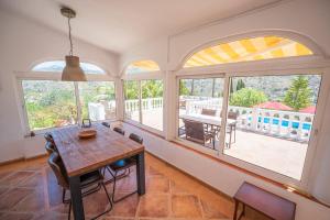 a dining room with a table and some windows at Casa Girasol in Torrox