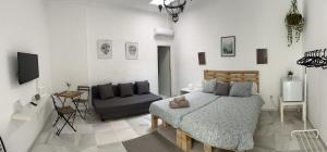 1 dormitorio con 1 cama y 1 sofá en BF BOUTIQUE JEREZ en Jerez de la Frontera