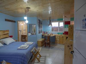 a bedroom with a bed and a kitchen with a sink at Cabañas La Lila in Huinganco