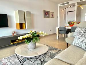 a living room with a vase of flowers on a table at Luxury apartment with stunning sea views in Sunset Cliff Benidorm in Benidorm