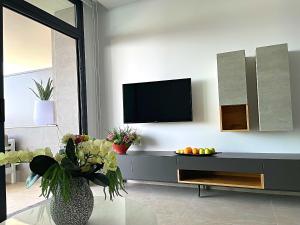 a living room with a tv and a vase of fruit at Luxury apartment with stunning sea views in Sunset Cliff Benidorm in Benidorm