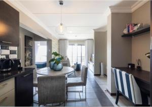 uma cozinha e sala de jantar com mesa e cadeiras em The Steynview Apartment - Fourways Sandton em Joanesburgo