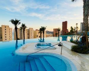 a swimming pool with a boat in the middle of a city at Luxury apartment with stunning sea views in Sunset Cliff Benidorm in Benidorm
