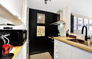 斯托漢的住宿－26#41 Chemin du Hameau (studio)，厨房配有白色橱柜和黑色墙壁