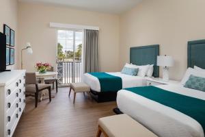 a hotel room with two beds and a balcony at The Capri Inn in Naples