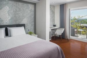 ein Schlafzimmer mit Bett, Schreibtisch und Fenster in der Unterkunft Hotel Tomi in Portorož + 50 Fotos