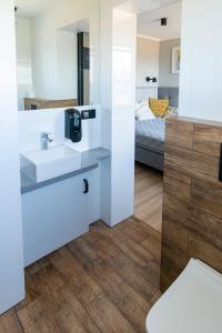 a bathroom with a sink and a bed in a room at REWA pokoje gościnne in Rewa