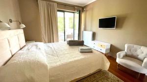 a bedroom with a bed and a chair and a television at Villa Muraj-Kornić, Krk in Kornić