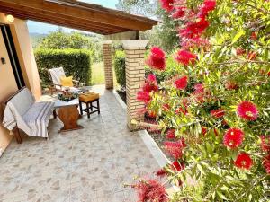 a patio with a bunch of red flowers on a wall at Renas Studio near Roda by DadoVillas in Roda