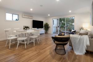 een woonkamer met een bank en een tafel met stoelen bij Beach Retreat in Sydney
