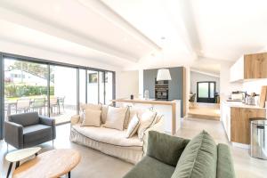 uma sala de estar com um sofá e uma mesa em Villa de 4 chambres avec piscine privee jardin clos et wifi a Seignosse a 5 km de la plage em Seignosse