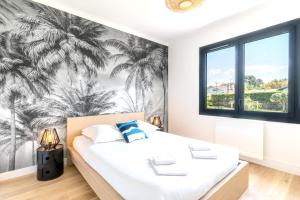 um quarto com uma cama e um mural de palmeiras em Villa de 4 chambres avec piscine privee jardin clos et wifi a Seignosse a 5 km de la plage em Seignosse