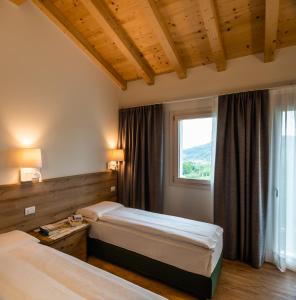 Agriturismo al Comarel في Tarzo: غرفة فندقية بسريرين ونافذة