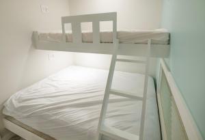 łóżko piętrowe z drabiną obok łóżka w obiekcie Sun Outdoors Cape May w mieście Cape May