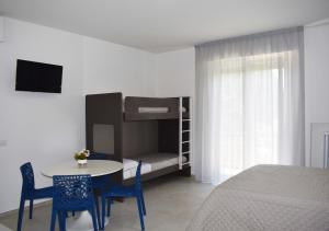 Marcelli Mare Camere Nel Conero في نومانا: غرفة نوم مع طاولة وكراسي وسرير بطابقين