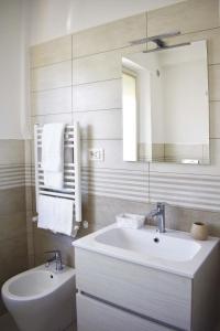 uma casa de banho com um lavatório, um espelho e um WC. em Marcelli Mare Camere Nel Conero em Numana