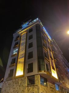 een hoog gebouw met lichten erop bij Avni Bey Otel in Araklı