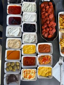 una mesa cubierta con bandejas de diferentes tipos de alimentos en Avni Bey Otel, en Araklı