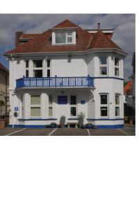 duży biały dom z niebieskim balkonem w obiekcie Southern Breeze Lodge - Adults Only w Bournemouth