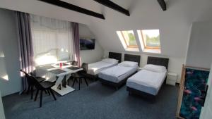 Zimmer mit 3 Betten, einem Schreibtisch und einem Tisch in der Unterkunft wczasypustkowo in Pustkowo