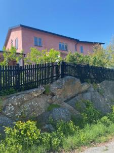 a fence and some rocks in front of a house at Vaxholm Apartment in Vaxholm