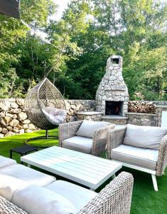 a patio with wicker furniture and a stone fireplace at Villa Muraj-Kornić, Krk in Kornić