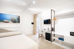 una camera bianca con letto e scrivania di Istedda Boutique Hotel a Solanas