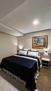 a bedroom with a large black bed with white pillows at Hotel Dan Inn Uberlandia in Uberlândia