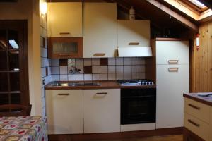 a kitchen with white cabinets and a sink and a stove at Pieralda's Home in Fiumalbo