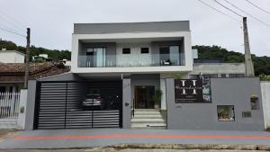 une maison avec un balcon au-dessus dans l'établissement Hospedaria da Barra BC, à Balneário Camboriú