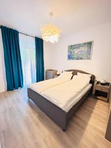 - une chambre avec un grand lit et des rideaux bleus dans l'établissement Apartment #12lunipebega Timisoara, à Timişoara
