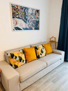 - un canapé avec des oreillers dans le salon dans l'établissement Apartment #12lunipebega Timisoara, à Timişoara