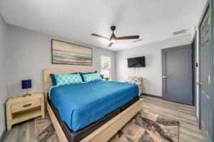 a bedroom with a bed and a ceiling fan at Bungalow 1mile from Beach TVs Games Backyard in Navarre