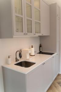 a kitchen with white cabinets and a sink at WUUD Pädaste in Simisti