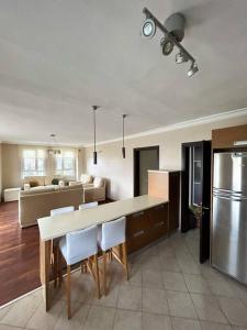 a kitchen and living room with a table and refrigerator at Somos Flats Kuşadası in Kusadası