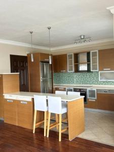 a kitchen with a table and white chairs at Somos Flats Kuşadası in Kusadası