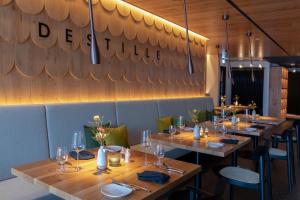 Wellness & Genuss Resort - Engel Obertal في بايرسبرون: غرفة طعام مع طاولات وكراسي خشبية مع أكواب