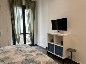 Schlafzimmer mit einem Bett und einem Flachbild-TV in der Unterkunft La Corte 25 in Marsala