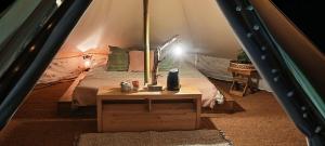 um quarto com uma cama e uma mesa numa tenda em Évasion en pleine nature, Tipi insolite à proximité du Pont du Gard ! em Vers Pont du Gard