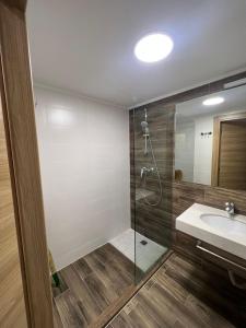 a bathroom with a shower and a sink at Orbi Palace Bakuriani Apartment in Bakuriani
