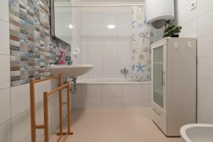 a white bathroom with a sink and a bath tub at Apartment LilyM in Rovinj +21 photos
