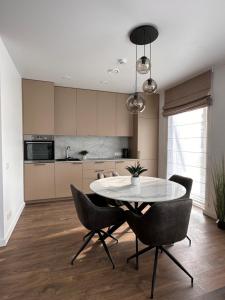 a kitchen with a table and chairs in a room at Palanga Waves Cottages in Kunigiskes in Palanga