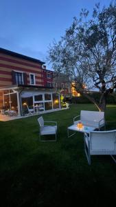 patio z 2 krzesłami i stołem w trawie w obiekcie Corte Caselle w mieście Sommacampagna