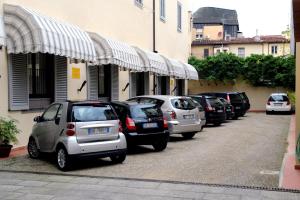 eine Reihe von Autos, die vor einem Gebäude geparkt sind in der Unterkunft Hotel Residence La Contessina in Florenz