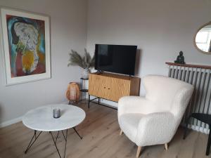 a living room with a chair and a television at Cosy apartment in the old west Reykjavik center in Reykjavík