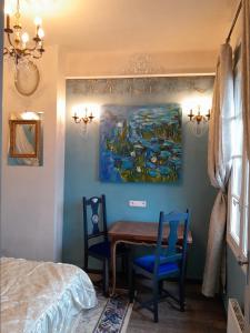 a dining room with a table and two chairs and a painting at Penthouse en bleu royal in Vinça